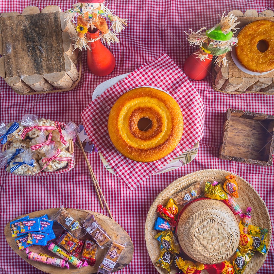 Festa junina, festa típica brasileira, vários doces na mesa com toalha xadrez vermelha.
