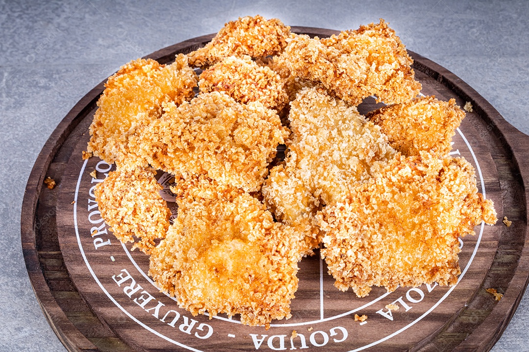 Delicioso frango frito em uma placa de madeira rústica com molho de tomate e maionese em um fundo de mármore. Vista frontal.