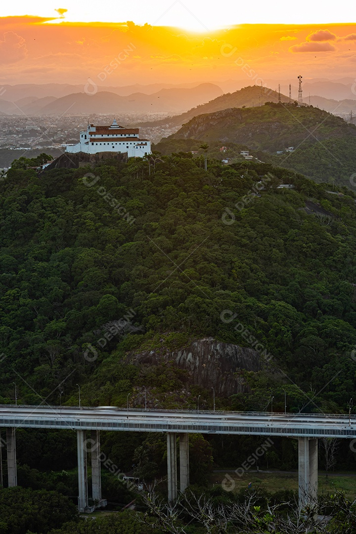 Fotografia do Convento da Penha ao entardecer, mostrando também as cidades de Vila Velha, Vitória e Terceira Ponte.