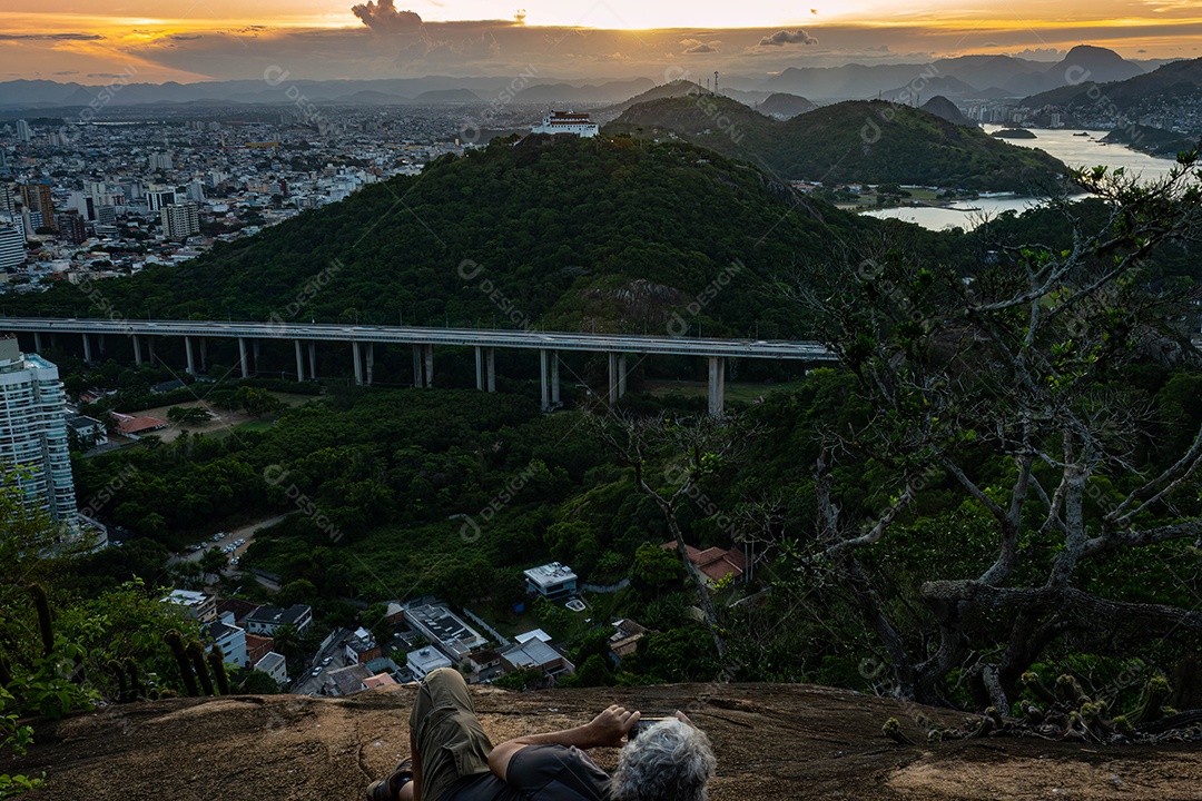 Fotografia do Convento da Penha ao entardecer, mostrando também as cidades de Vila Velha, Vitória e Terceira Ponte.