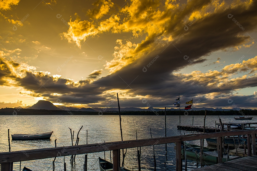 Pôr do sol com barco em primeiro plano e montanha mochuara ao fundo.