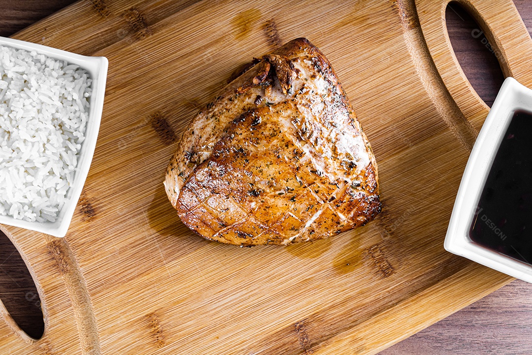 Bife de porco assado em uma tábua de madeira e fatiado