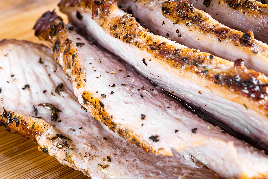 Bife de porco assado em uma tábua de madeira e fatiado