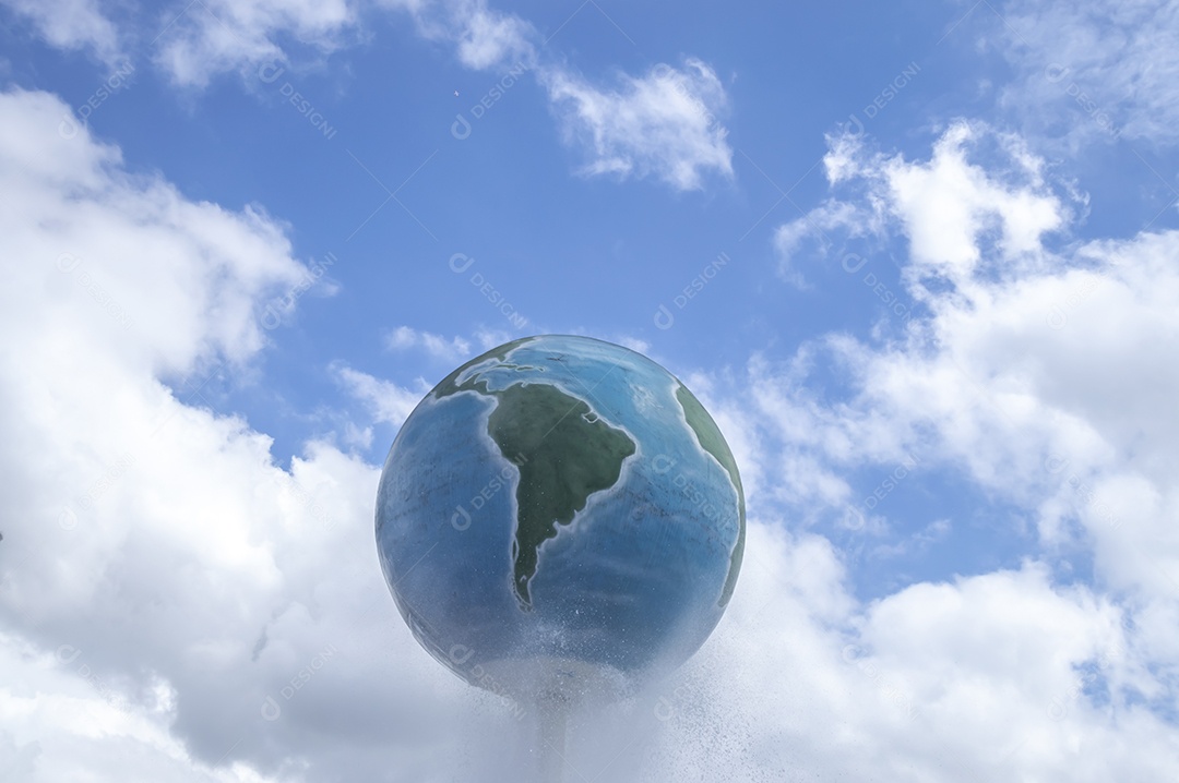 Estrutura do planeta Terra com céu azul e nuvens ao fundo.