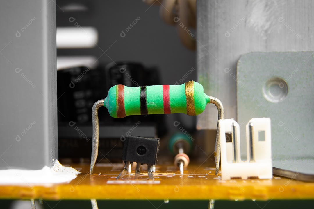 Resistor de filme de carbono com uma cor verde na placa de circuito eletrônico do aparelho elétrico, conceito de peça eletrônica.