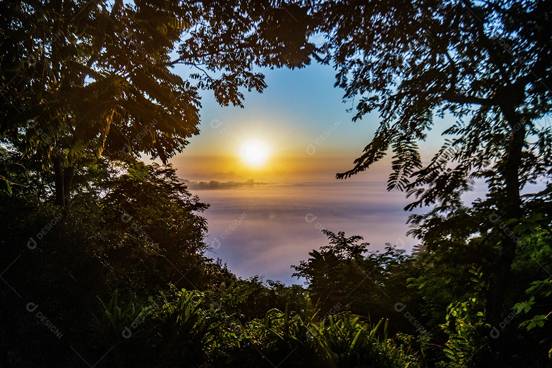 Nascer do sol no mirante do penhasco com a praia do Leblon ao fundo sobre densa neblina no Rio de Janeiro, Brasil