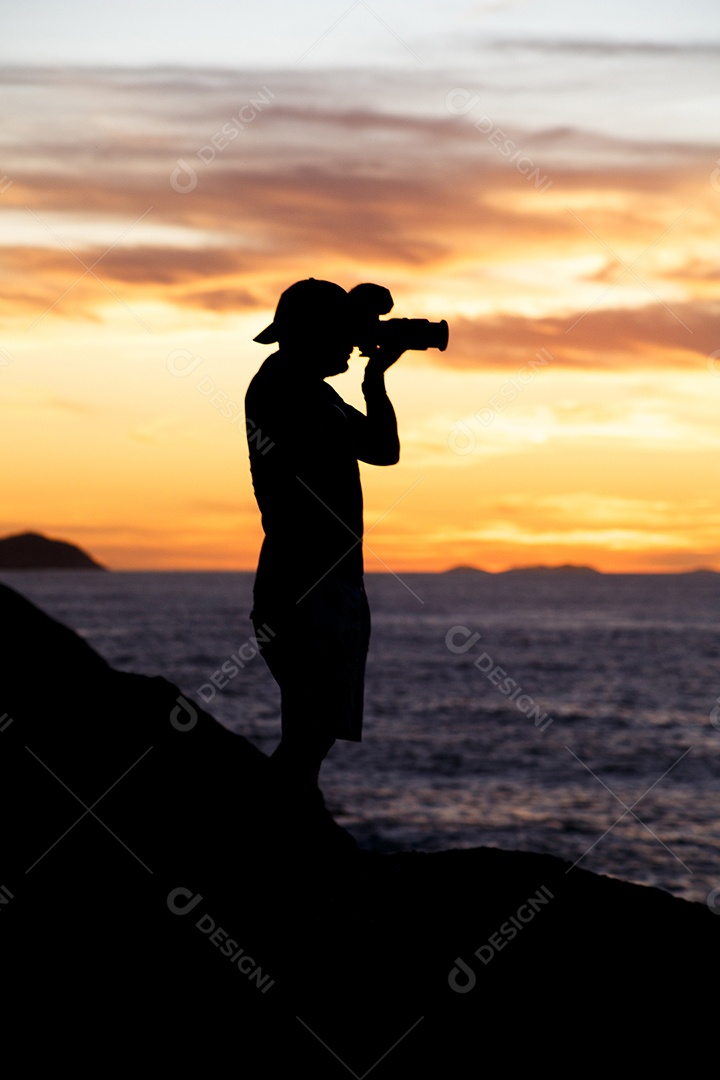 Silhueta de um fotógrafo com um lindo nascer do sol ao fundo na praia do Leblon, no Rio de Janeiro, Brasil.