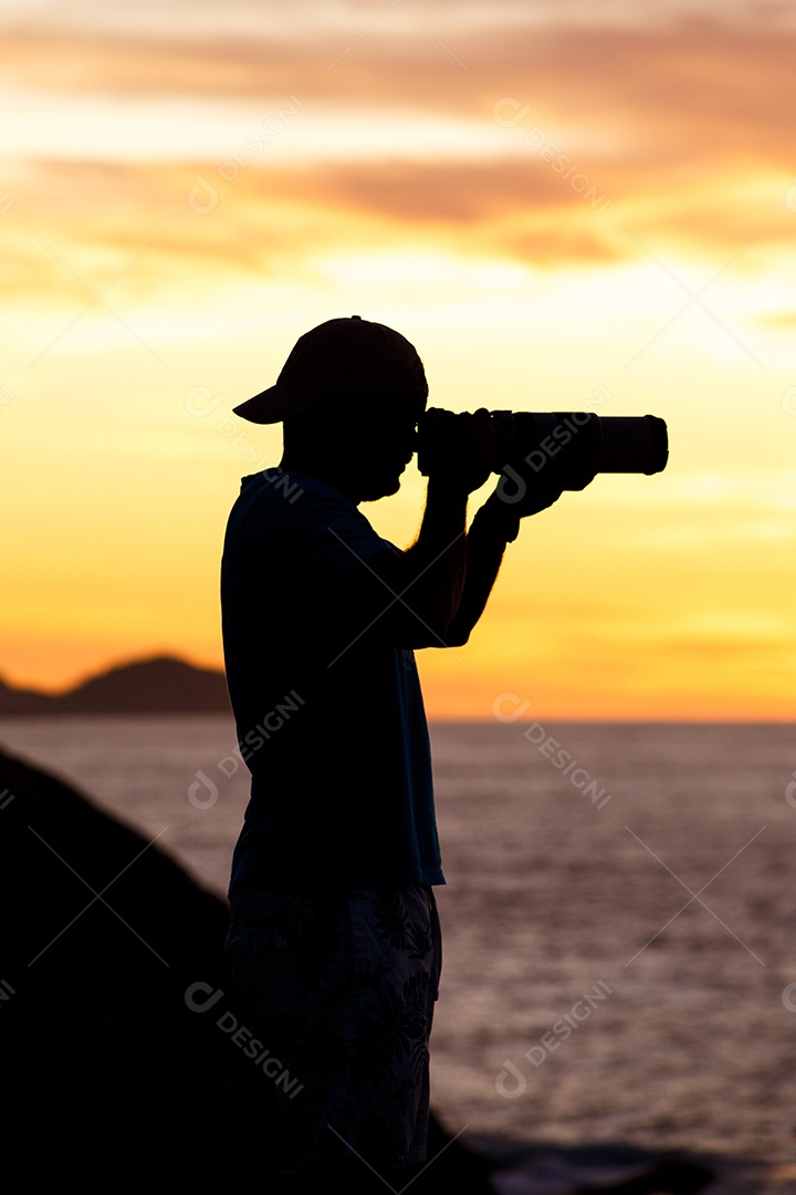 Silhueta de um fotógrafo com um lindo nascer do sol ao fundo na praia do Leblon, no Rio de Janeiro, Brasil.