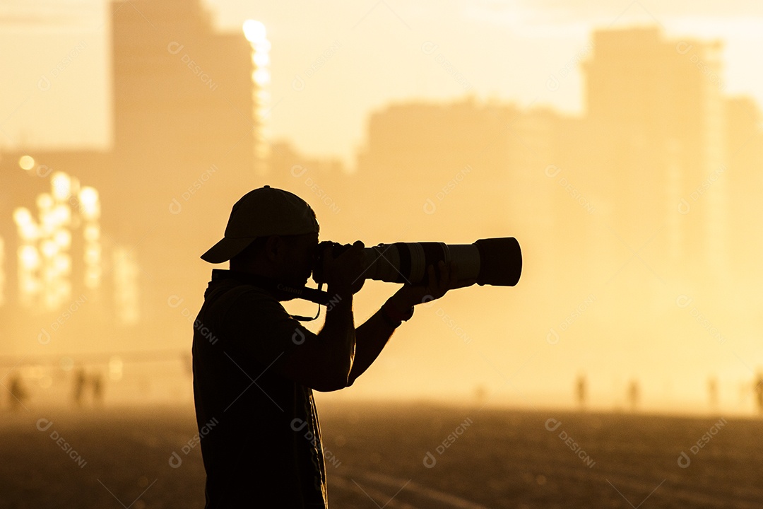 Silhueta de um fotógrafo com um lindo nascer do sol ao fundo na praia do Leblon, no Rio de Janeiro, Brasil.