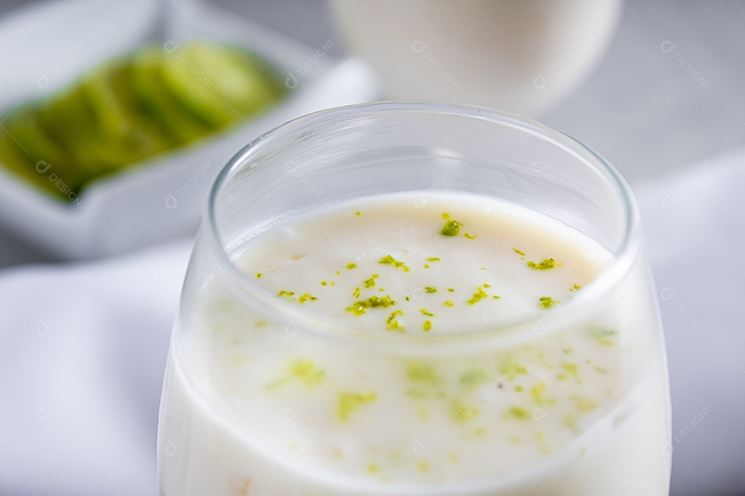 Deliciosa mousse de limão sobre uma tábua de madeira e um fundo de mesa branco, com uma toalha branca em volta e uma colher de metal