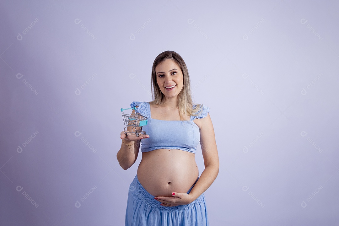 Linda mulher jovem grávida segurando carrinho de supermercado sobre fundo isolado