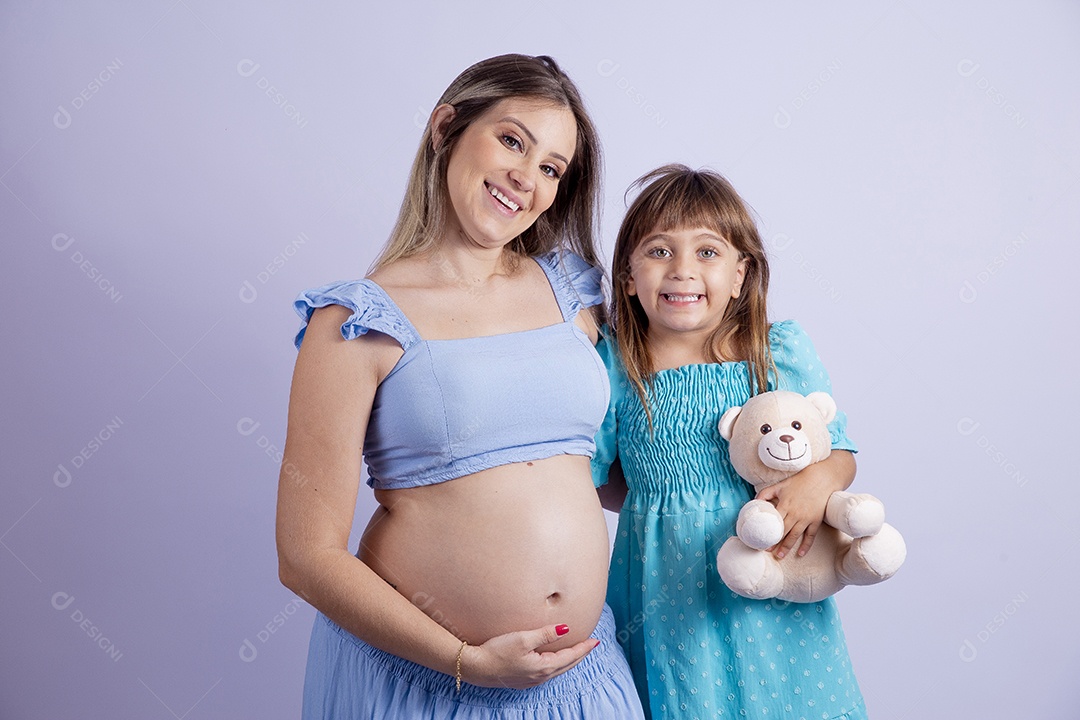 Linda mulher jovem gravida ao lado de sua filha sobre fundo isolado