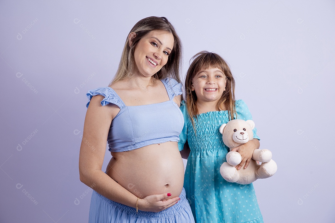 Linda mulher jovem gravida ao lado de sua filha sobre fundo isolado