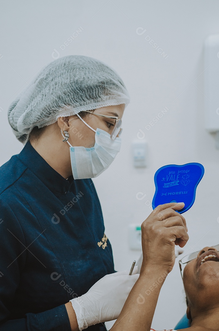 Dentista sobre seu consultorio odontológico atendendo seu paciente