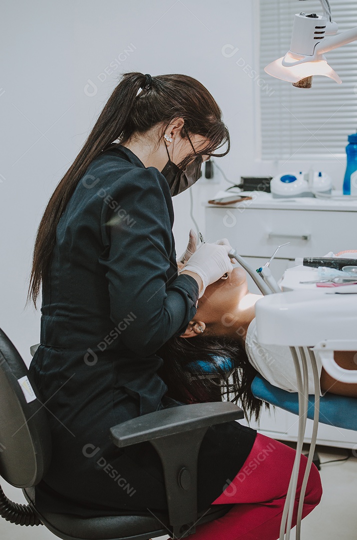 Dentista sobre seu consultorio odontológico atendendo seu paciente