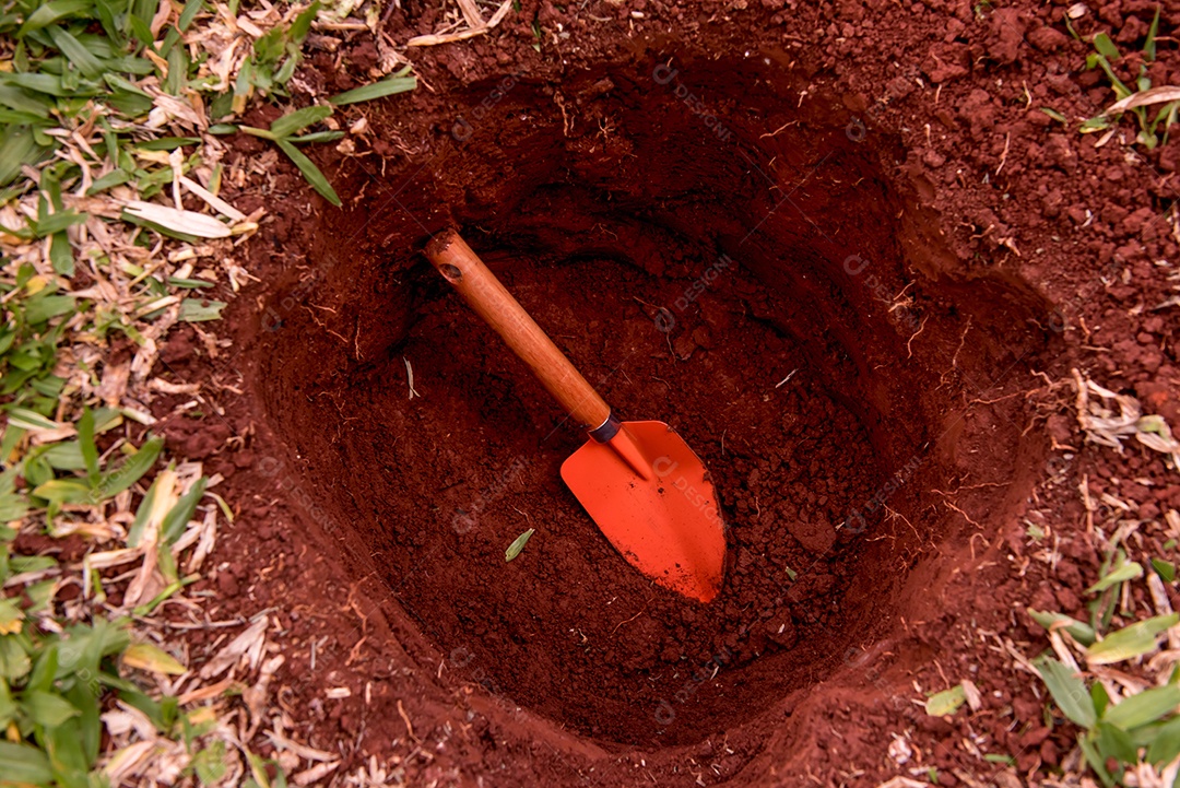Pá de jardinagem dentro de um buraco no jardim