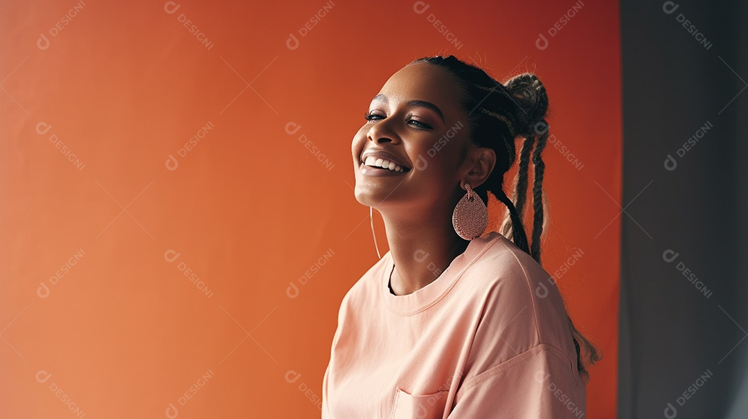 Alegre jovem adulta sorrindo com os dentes expostos em um retrato de tiro de estúdio contra um fundo colorido