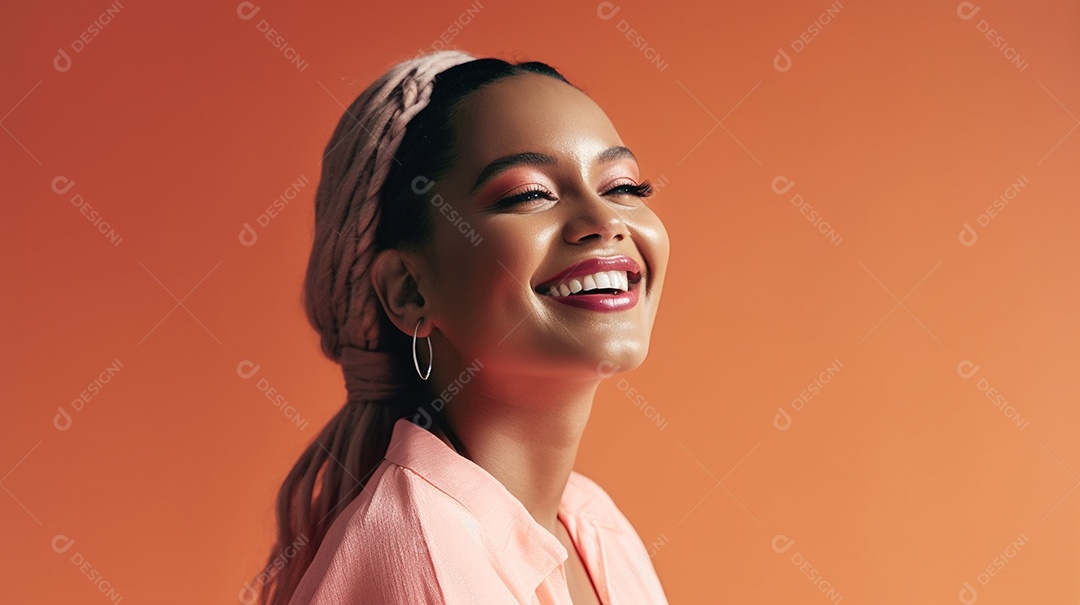 Alegre jovem adulta sorrindo com os dentes expostos em um retrato de tiro de estúdio contra um fundo colorido, expressando imensa felicidade.