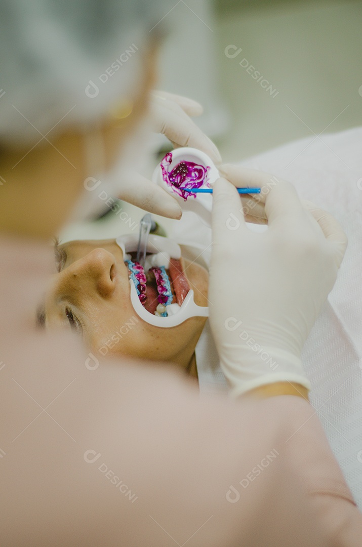 Dentista sobre seu consultorio odontológico atendendo seu paciente