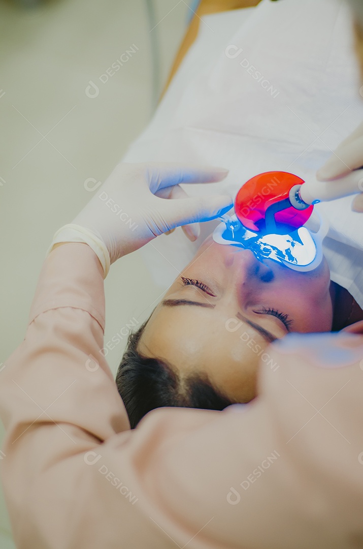 Dentista sobre seu consultorio odontológico atendendo seu paciente