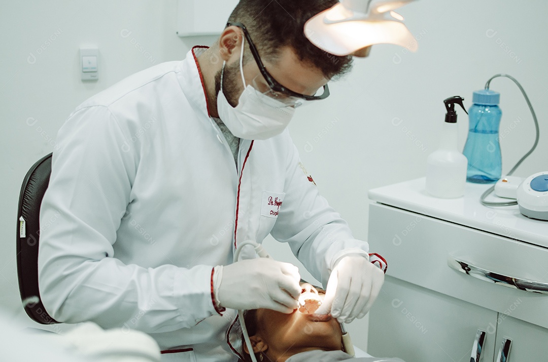 Dentista sobre seu consultorio odontológico atendendo seu paciente
