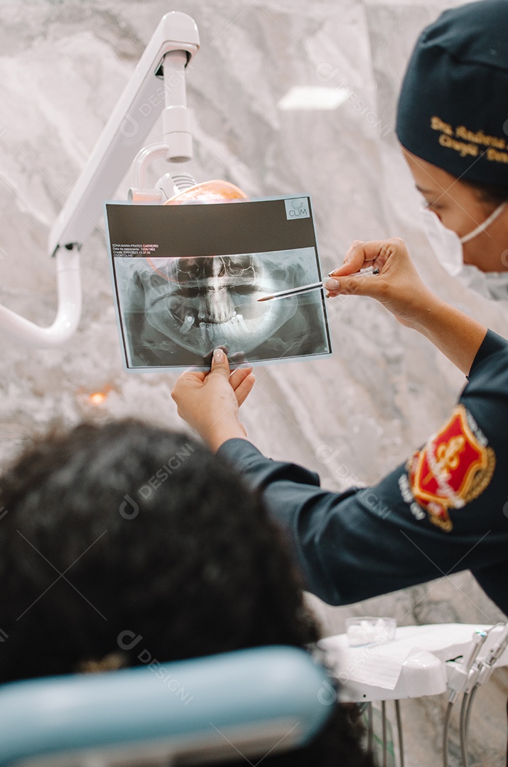 Dentista sobre seu consultorio odontológico atendendo seu paciente