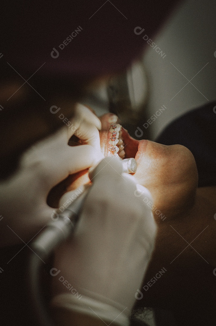Dentista sobre seu consultorio odontológico atendendo seu paciente