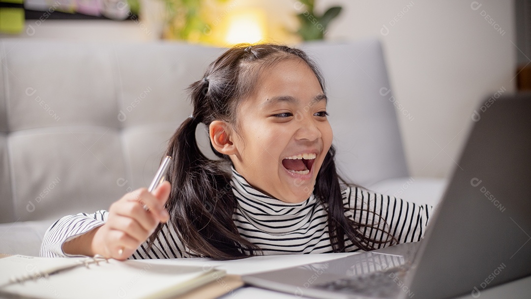 Menina asiática tendo uma aula online e feliz pelo ensino em casa.