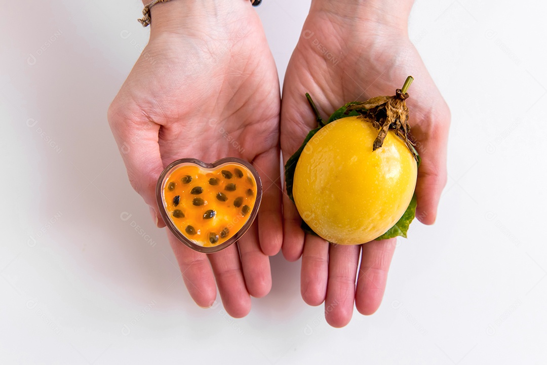 Mãos segurando maracujá e mousse de maracujá