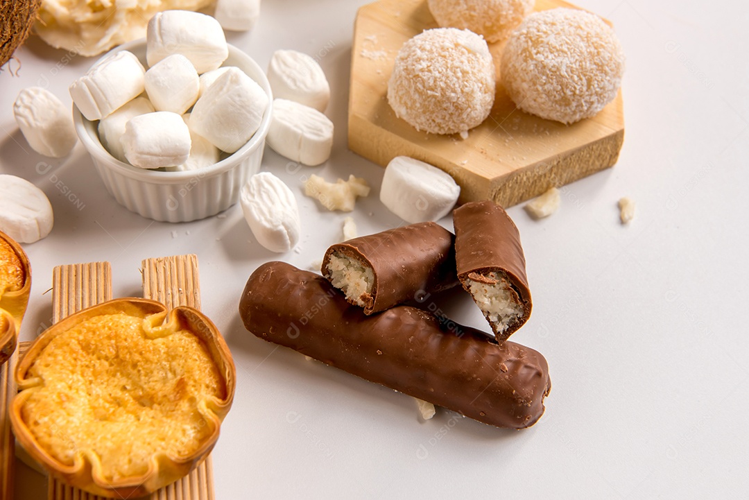 Beijinho de coco, chocolate de coco e doce de coco (cocada) em fundo branco