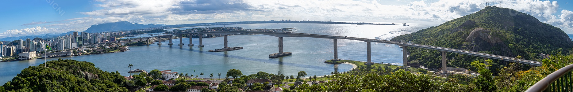 Grande foto panorâmica mostrando a cidade de Vitória, baía de Vitória, terceira ponte, porto dos tubarões e o morro do moreno.