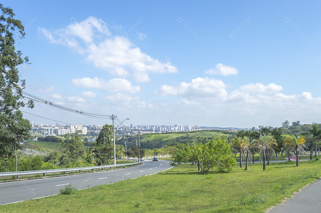 Vista distante da cidade de campinas sp em um dia ensolarado com uma ciclovia à direita da imagem