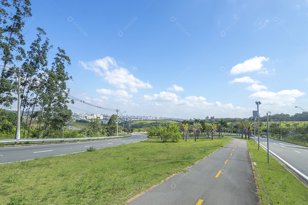 Vista distante da cidade de campinas sp em um dia ensolarado com uma ciclovia à direita da imagem