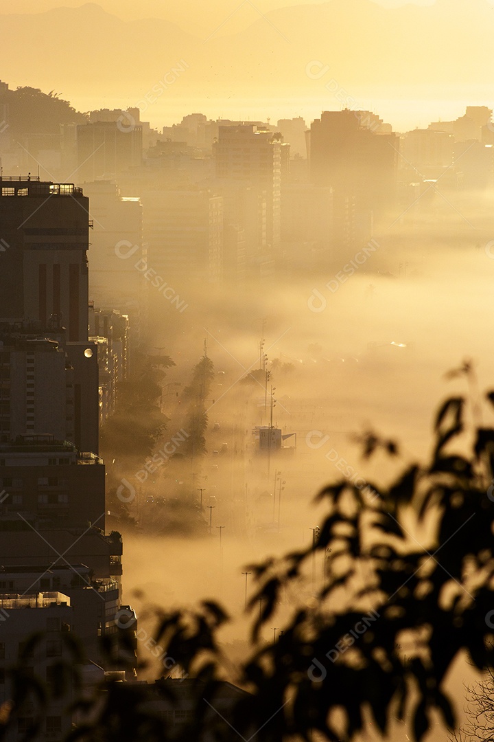 Nascer do sol no mirante do penhasco com a praia do Leblon ao fundo sobre densa neblina no Rio de Janeiro, Brasil
