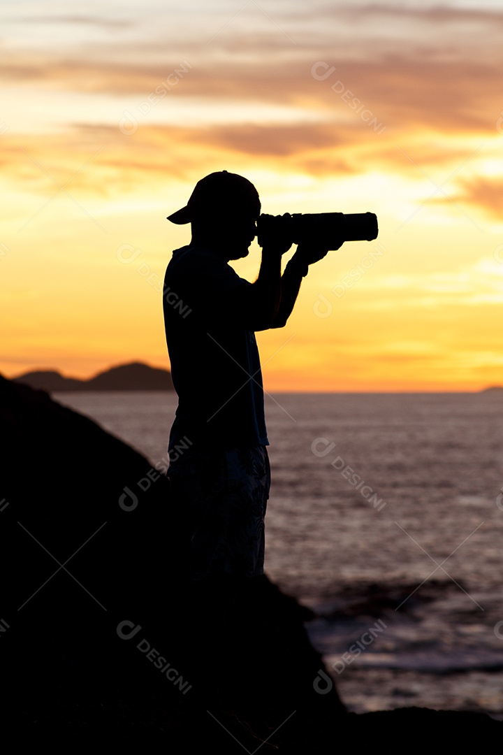 Silhueta de um fotógrafo com um lindo nascer do sol ao fundo na praia do Leblon, no Rio de Janeiro, Brasil.