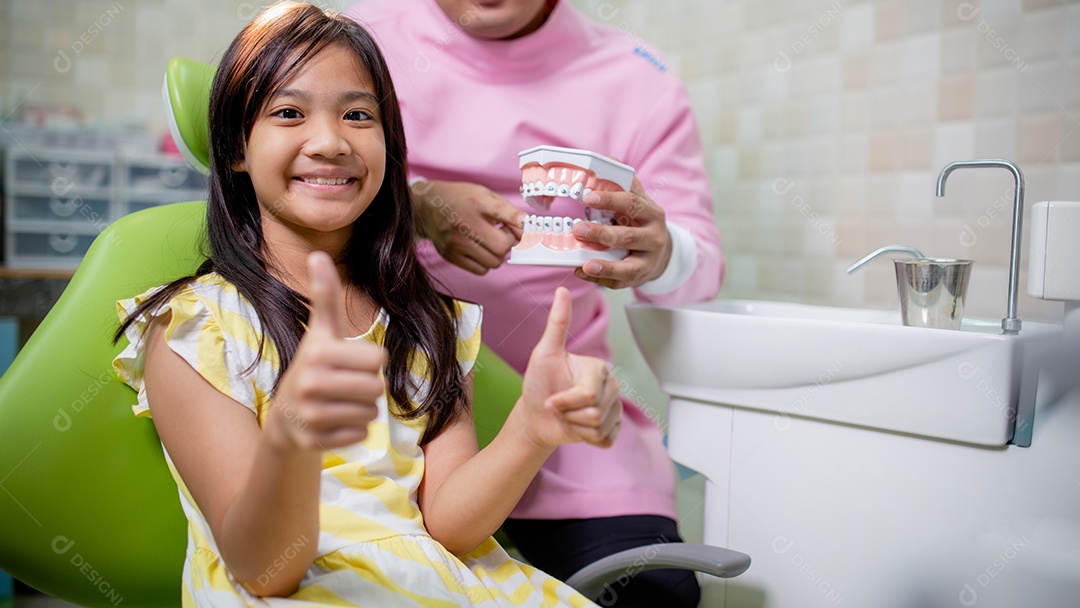 Os dentes das meninas asiáticas são saudáveis ​​no consultório odontológico.