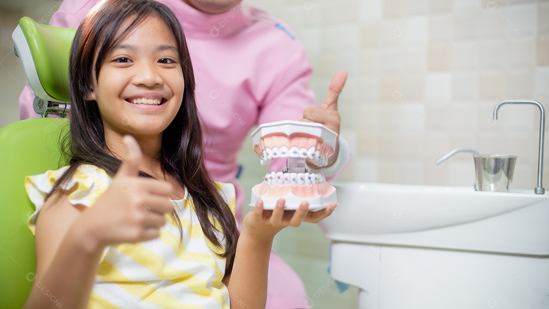 Os dentes das meninas asiáticas são saudáveis ​​no consultório odontológico.