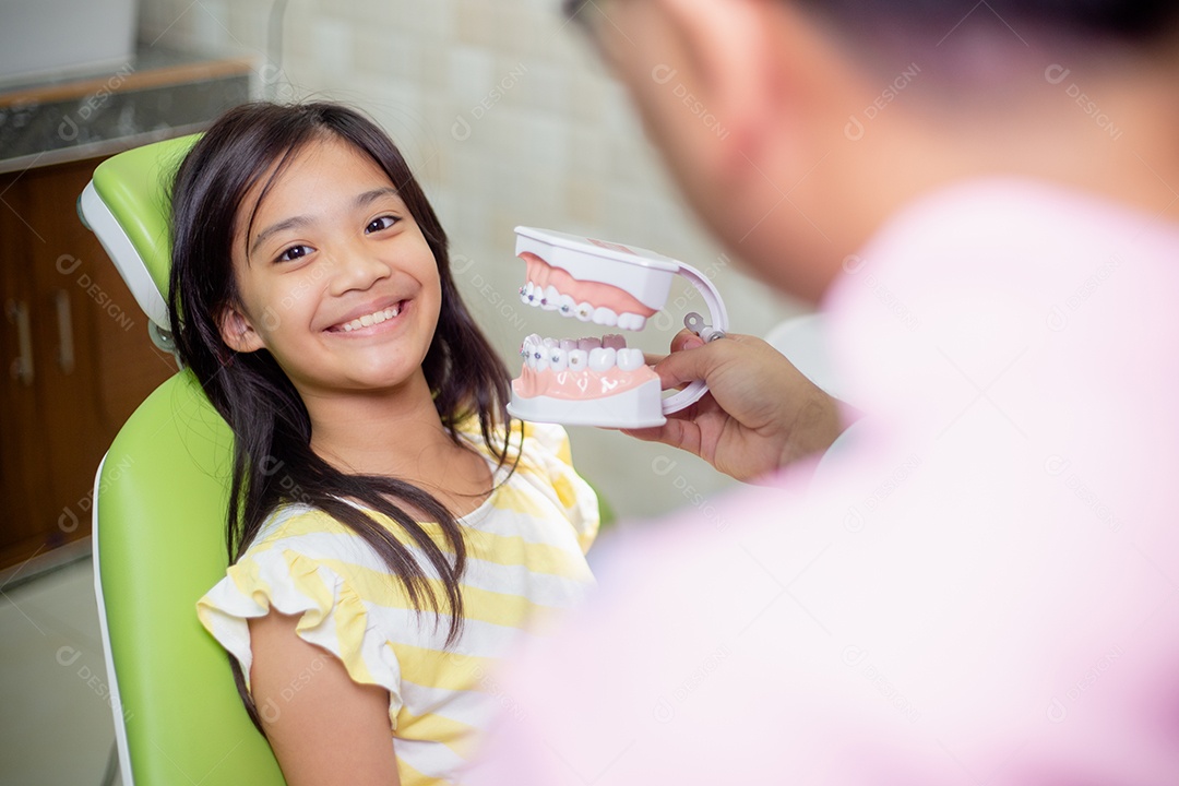 Os dentes das meninas asiáticas são saudáveis ​​no consultório odontológico.