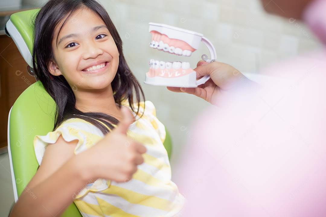 Os dentes das meninas asiáticas são saudáveis ​​no consultório odontológico.