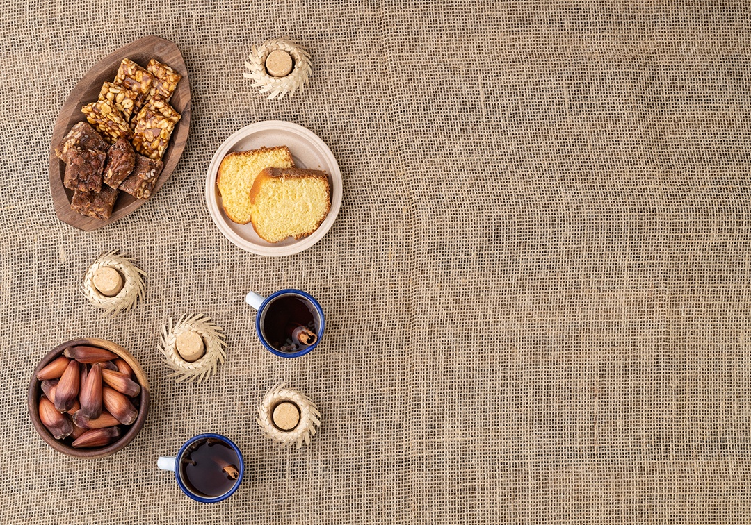 Comida típica da festa junina brasileira sobre tecido de juta. Festa junina com espaço para texto.