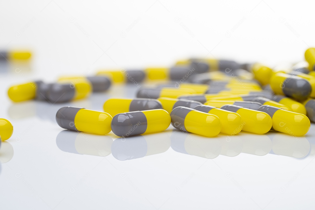 Pílula probiótica amarelo-branca em fundo branco