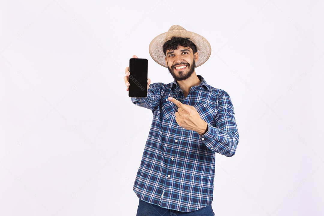 Homem jovem barbudo fantasiada celebrando festas juninas segurando celular smartphone