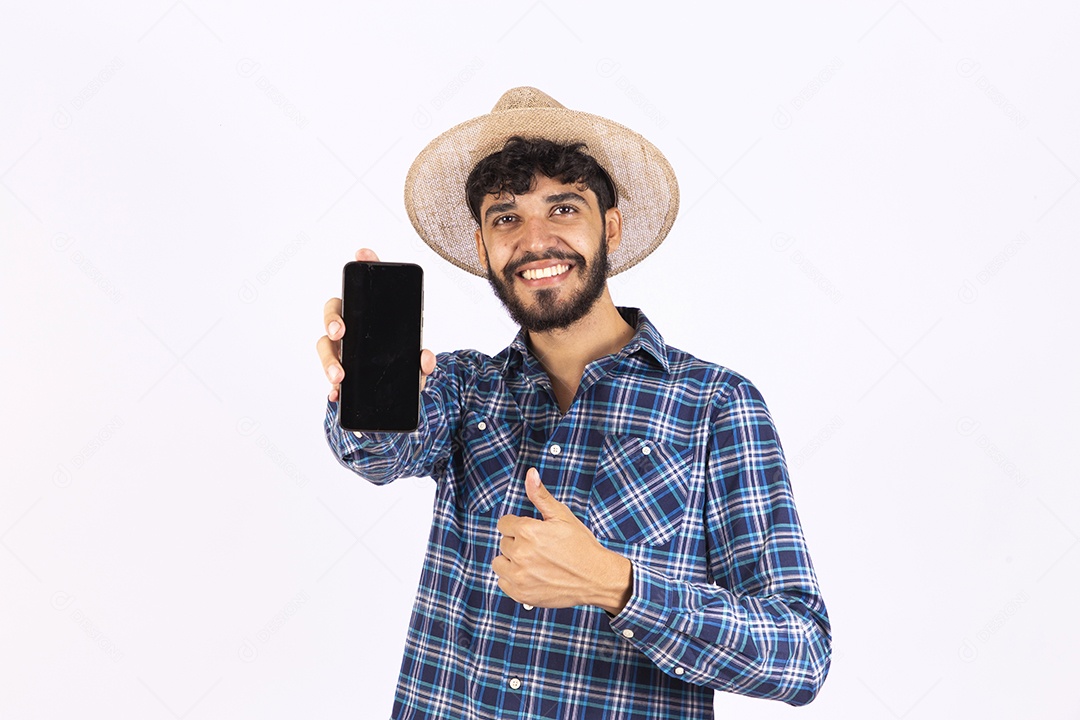 Homem jovem barbudo fantasiada celebrando festas juninas segurando celular smartphone