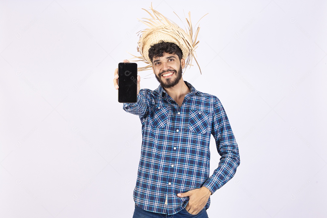 Homem jovem barbudo fantasiada celebrando festas juninas segurando celular smartphone