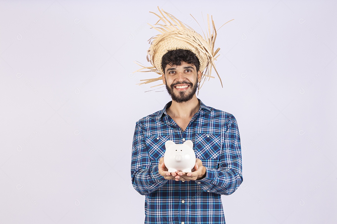 Homem jovem barbudo fantasiada celebrando festas juninas segurando cofre