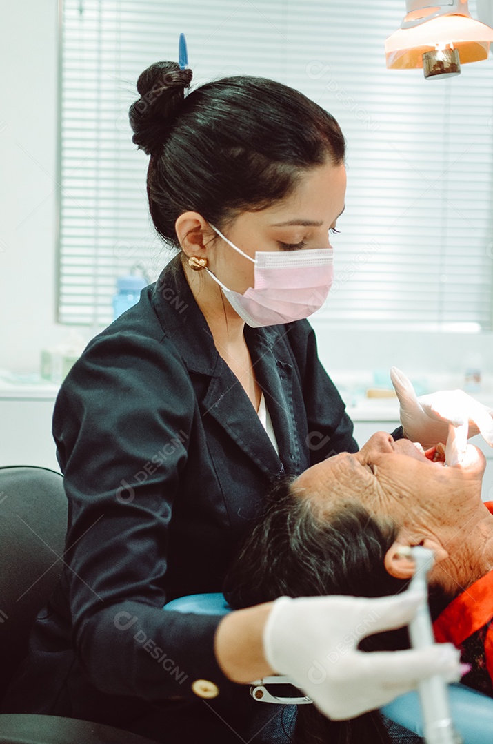 Dentista sobre seu consultorio odontológico atendendo seu paciente