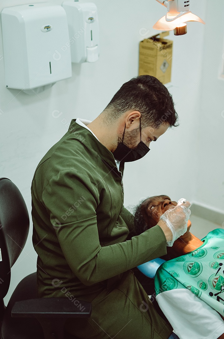 Dentista sobre seu consultorio odontológico atendendo seu paciente