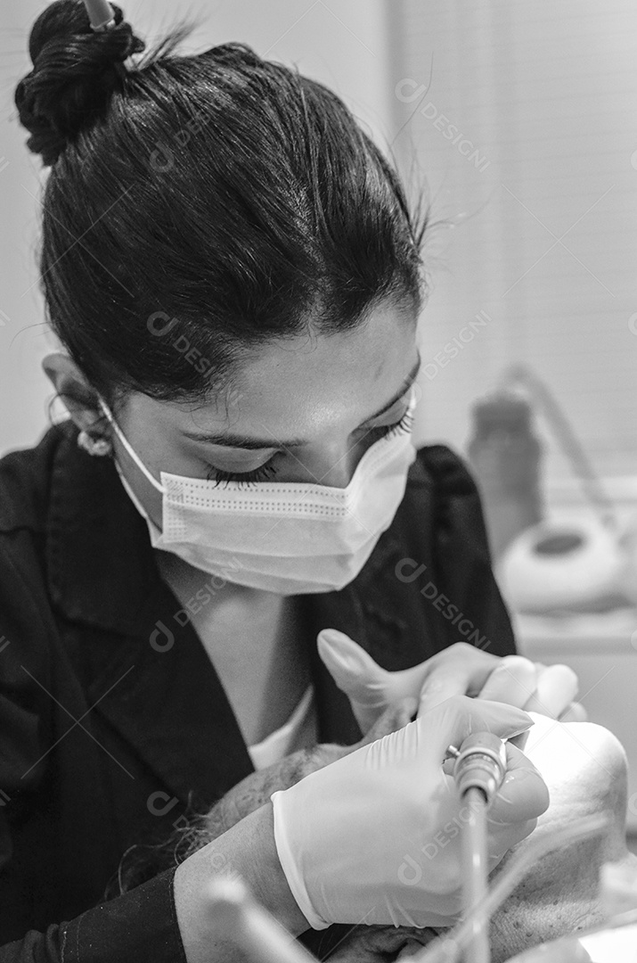 Dentista sobre seu consultorio odontológico atendendo seu paciente