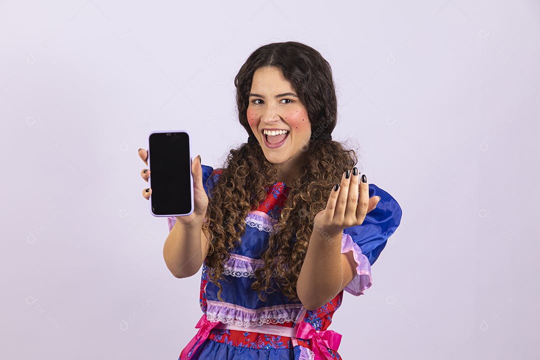 Linda mulher jovem fantasiada celebrando festas juninas segurando celular smartphone