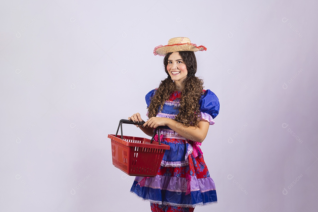Linda mulher jovem fantasiada celebrando festas juninas segurando cesta de mercado